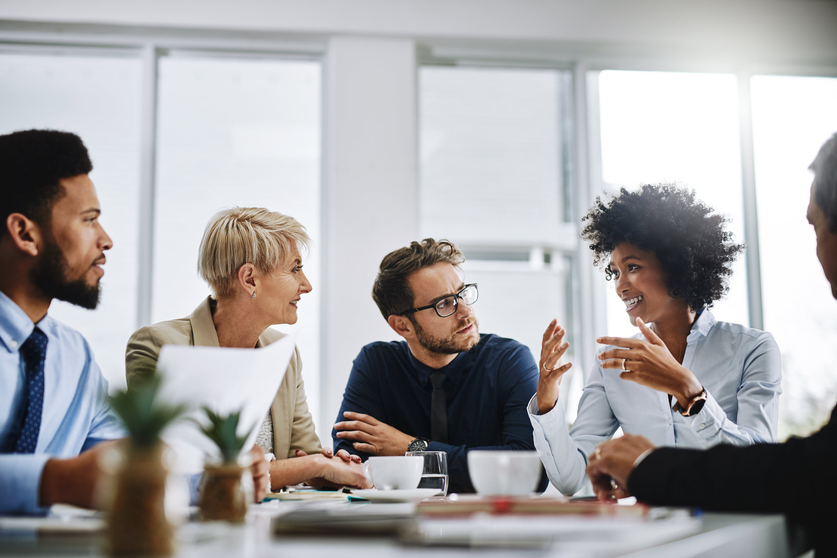 A group of business professionals sit around a table to collaborate on their latest project.