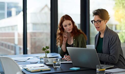 two business women working on a laptop