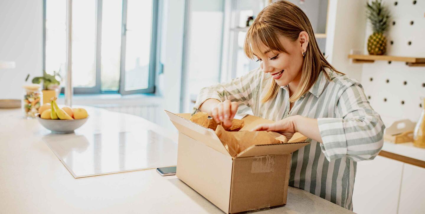 A young woman is at home, she unpacks delivered package