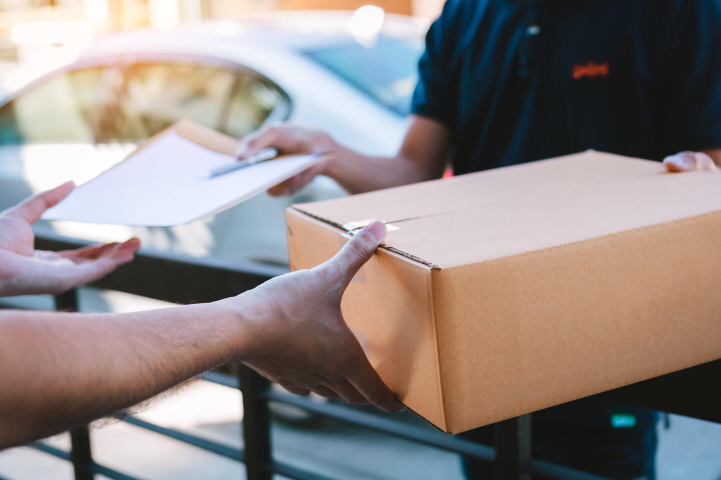 A customer signing for their package, which arrived thanks to address cleansing tax technology.