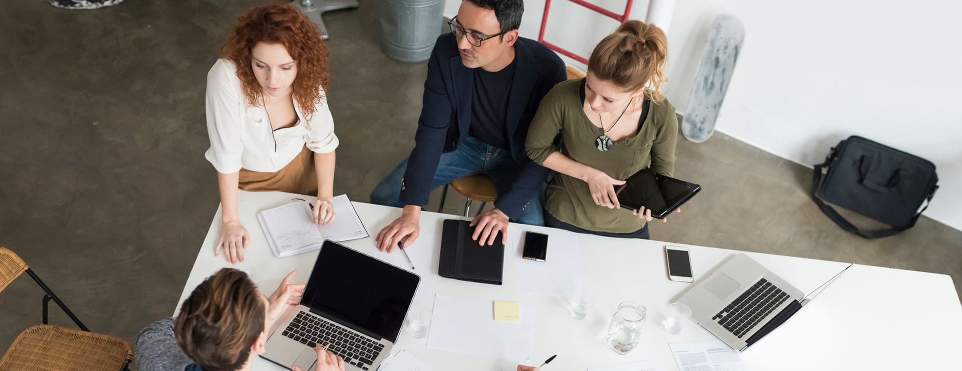 A group of individuals from a small business gathered around a table discussing business growth.